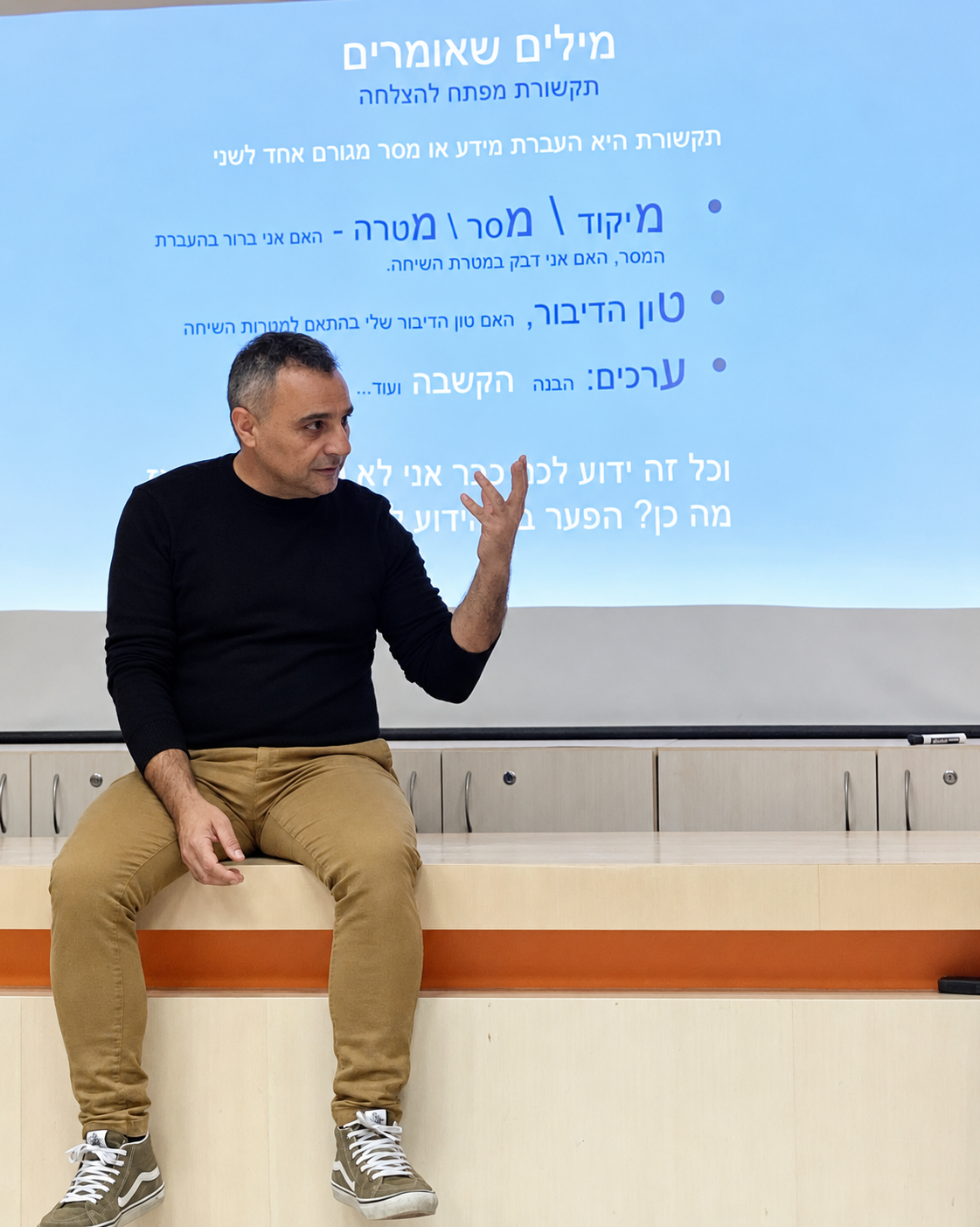 עמית בהרצאה עם מצגת על מילים שאנחנו אומרים